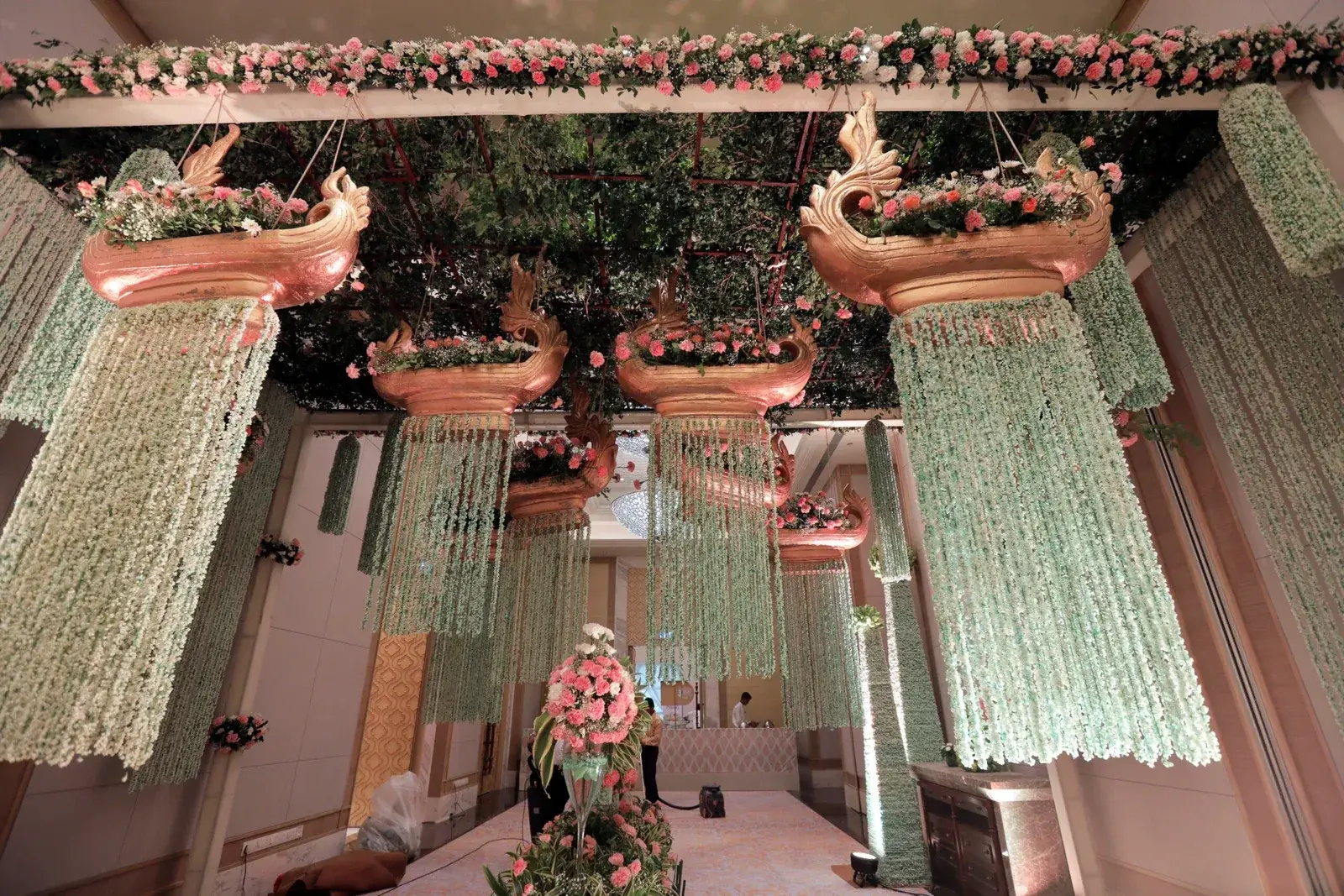 Floral ceiling canopy with hanging garlands and brass urlis at a Lucknow wedding