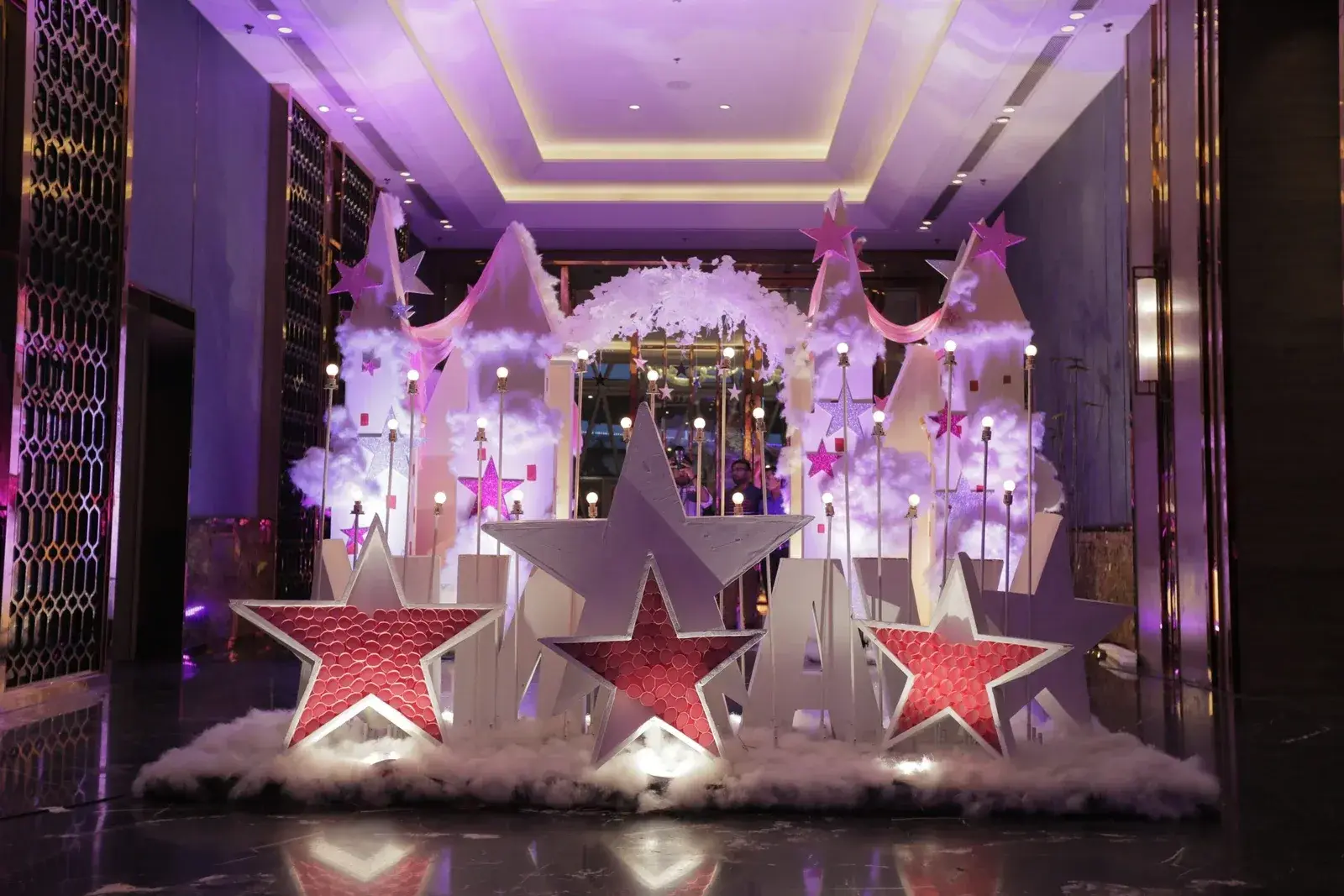 Star theme birthday stage with feather trees and pink uplighting in Lucknow
