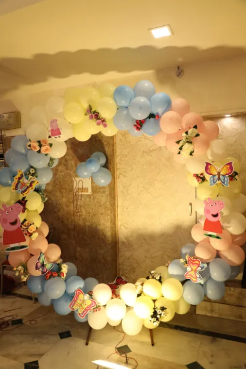Circular balloon ring arch with cartoon cut-outs for a kids birthday party in Lucknow