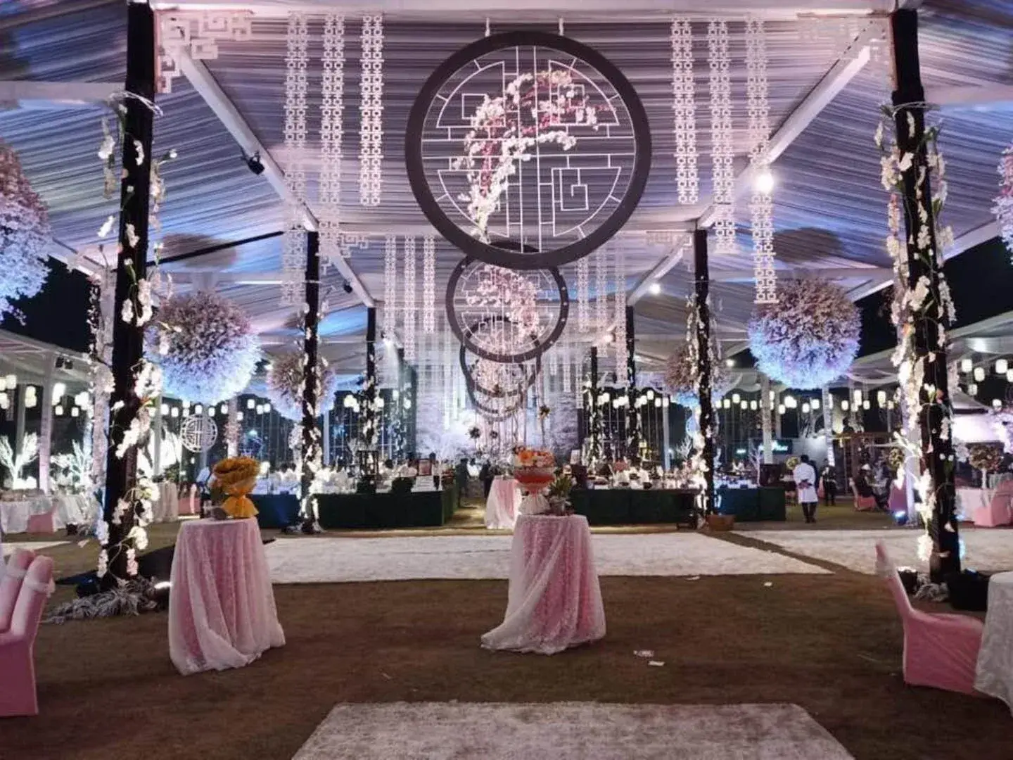 Marquee lawn setup with hanging floral hoops and draped pillars for a social celebration in Lucknow