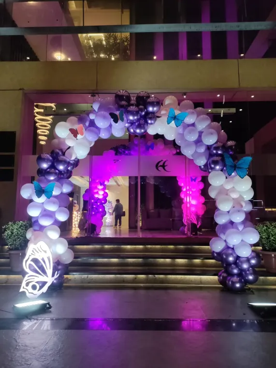 Purple and white balloon entrance arch with butterfly cut-outs for a first birthday in Lucknow