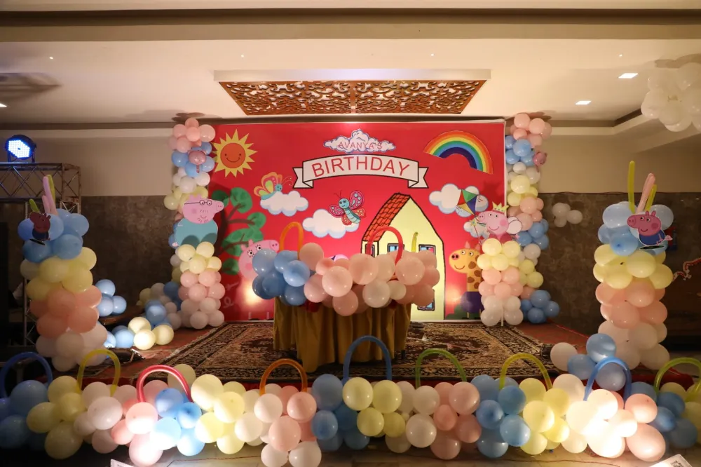 Printed cartoon backdrop and pastel balloon columns at a kids birthday party in Lucknow