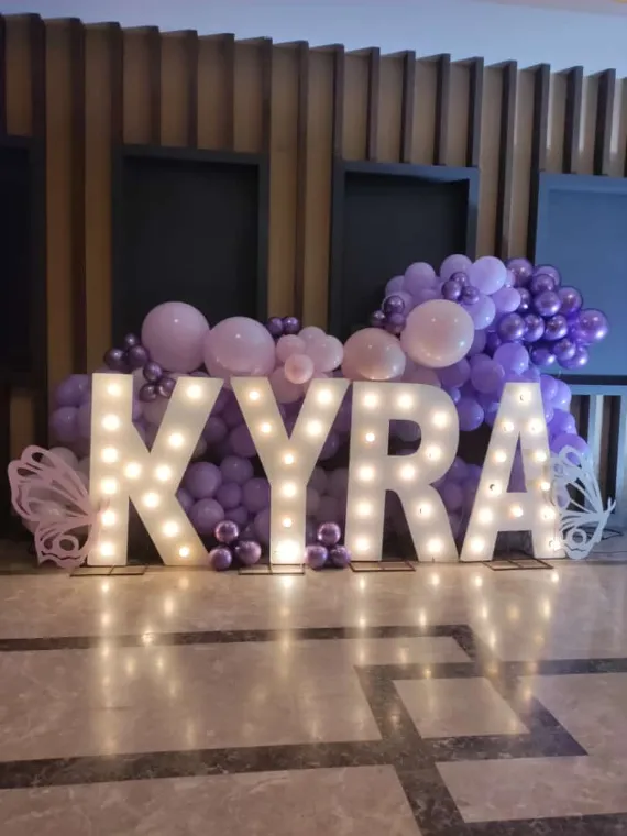 Illuminated marquee letters with a lilac balloon cluster at a Lucknow birthday party